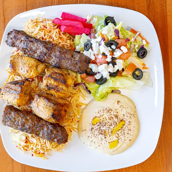 Halal Bites' platter with grilled chicken, kebab, rice, salad, pickled vegetables, and hummus.