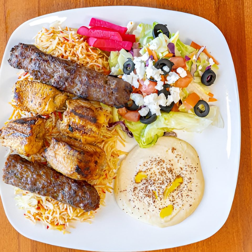 Halal Bites' platter with grilled chicken, kebab, rice, salad, pickled vegetables, and hummus.