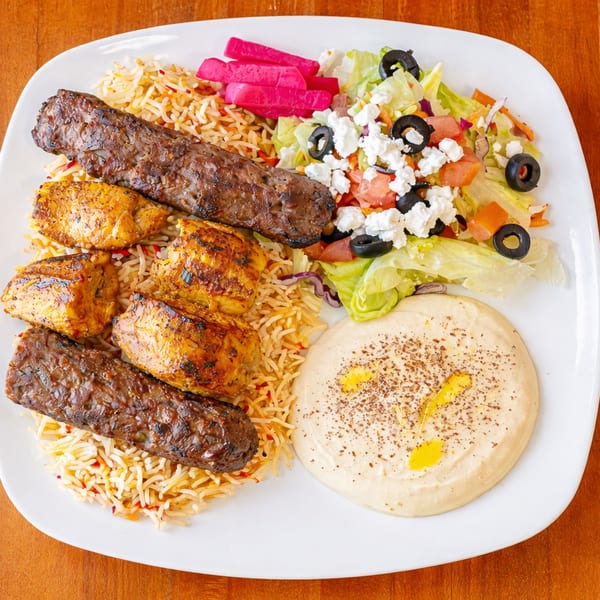 Halal Bites' platter with chicken and beef kebabs, rice, salad, pickled turnips, and hummus.
